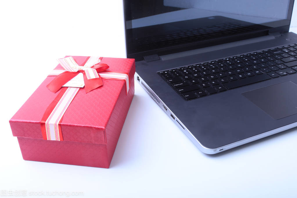 笔记本电脑和圣诞礼品盒白色办公桌